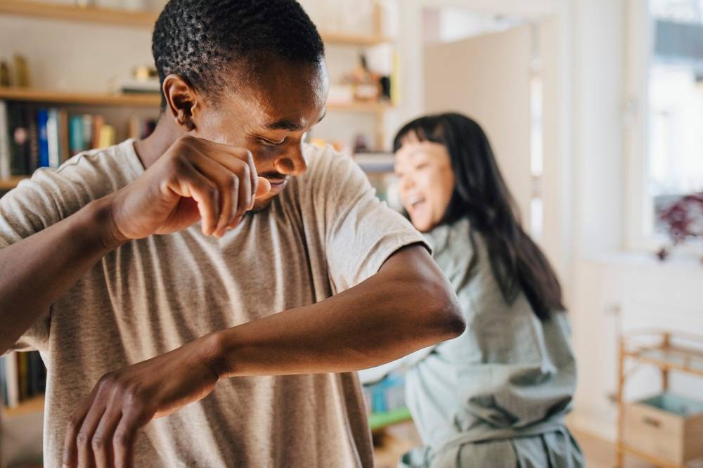 A young couple dancing at home after buying health insurance.