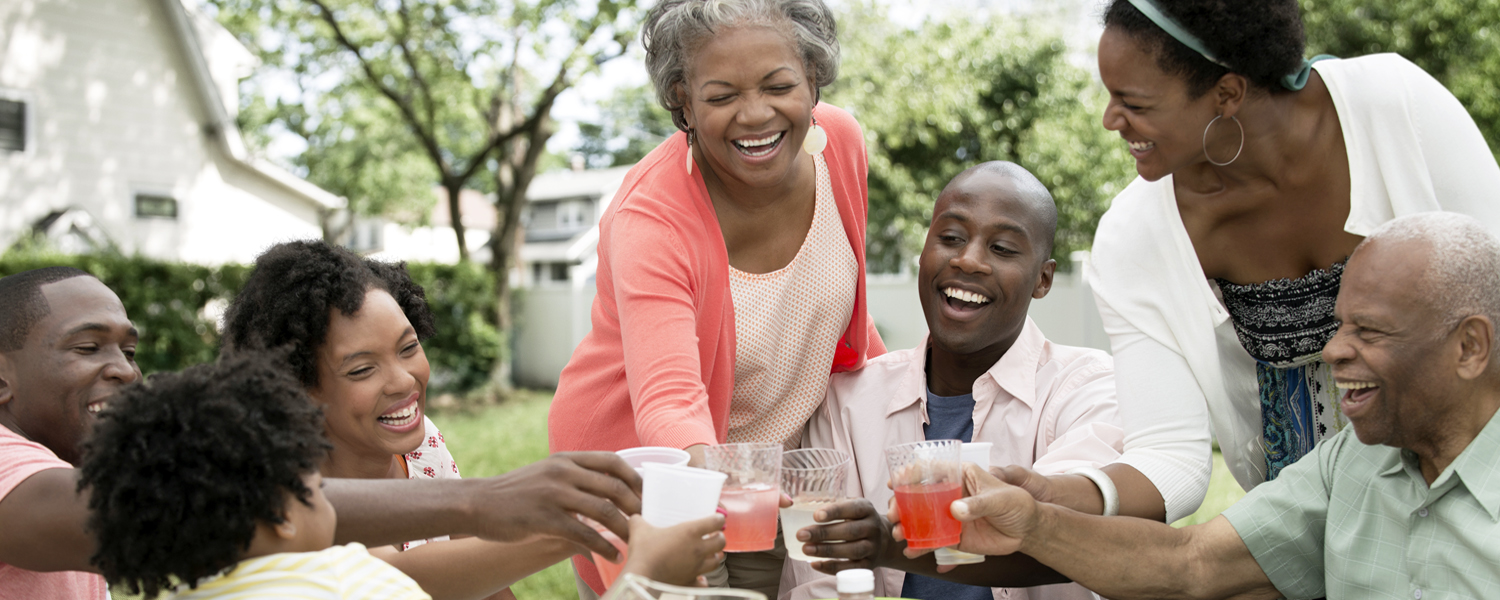 A family smiles and clinks drinks glasses outside